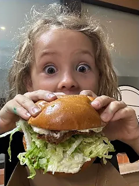 A young customer taking on a chicken burger, on Instagram